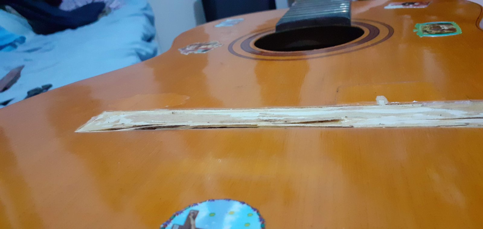 Rachadura no tampo do violão DiGiorgio 18 próxima à boca, antes do reparo